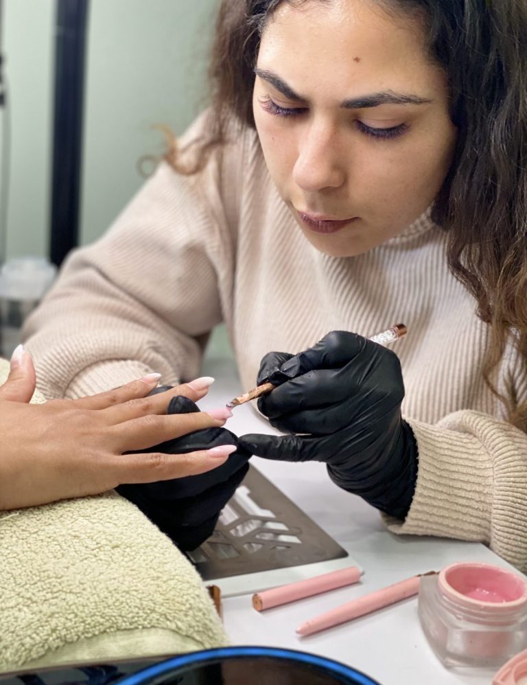 Pose de vernis semi-permanent sur ongles naturels par esthéticienne en soin beauté des mains